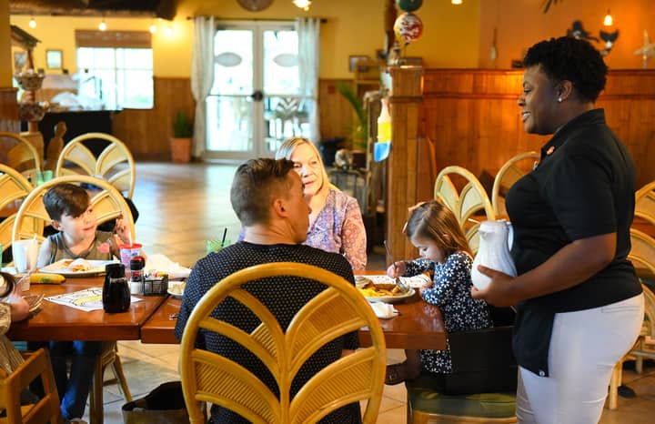 Family speaking to waitress at Orange Lake Resort near Orlando, Florida
