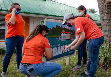 HICV Team Member help setup the festive decor outside of their Villa at Give Kids the World.